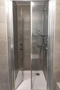 a shower with a glass door in a bathroom at FirstSleep Landshut in Landshut