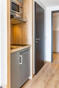 La cocina está equipada con lavavajillas y microondas. en FirstSleep Landshut en Landshut