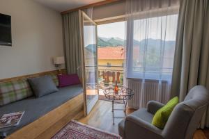 a living room with a couch and a balcony at Landgasthof Kirchenwirt in Grossraming