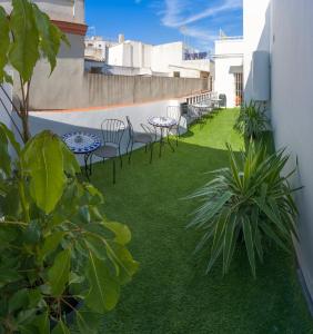 un patio con sillas y mesas en un balcón en Downtown Apartment (4 bedrooms, 2 bathrooms, wifi), en Sevilla