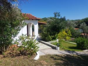 un pequeño edificio blanco con un camino en un jardín en Kaiti Villa 4 en Koukounaries