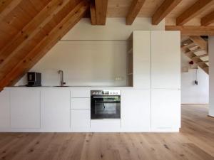 a kitchen with white cabinets and a wooden floor at Haus Mühlenfranzenhof in Schonwald im Schwarzwald