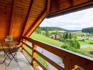 desde el balcón de una cabaña de madera con mesa y sillas en Haus Mühlenfranzenhof en Schönwald