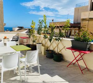 a patio with tables and chairs and plants on a roof at Casa Helios in Castellammare del Golfo