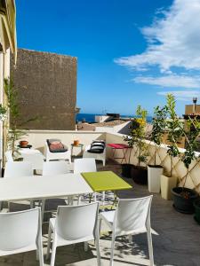 a patio with tables and chairs on a roof at Casa Helios in Castellammare del Golfo