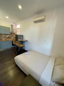 Habitación con cama y cocina con escritorio. en Studio Apartment Diadora Zadar free parking! en Zadar
