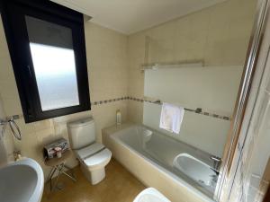 a bathroom with a tub and a toilet and a sink at Amplio apartamento con Garaje in Suances