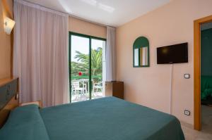 a bedroom with a bed and a large window at Medplaya Hotel Pino Alto in Miami Platja