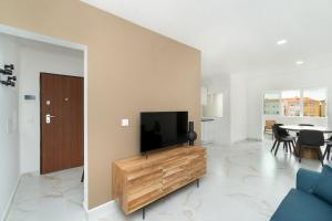 sala de estar con TV de pantalla plana en un centro de entretenimiento de madera en Estrela Do Mar Apartment by Olala Homes en Cascais
