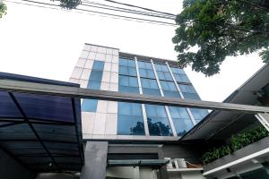 un edificio con ventanas de cristal en un lateral en RedDoorz near Kebon Jeruk Jakarta, en Yakarta