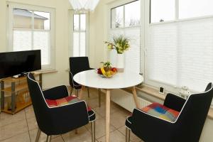 een eetkamer met een tafel, stoelen en een tv bij Uns Huesung in Ahlbeck