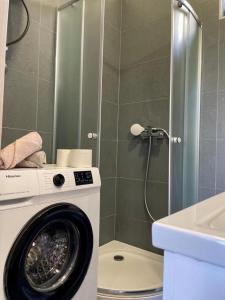 een wasmachine in een badkamer met een douche bij Studio Apartment Diadora Zadar free parking! in Zadar