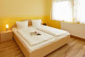 een slaapkamer met een groot bed met een boek erop bij Uns Huesung in Ahlbeck