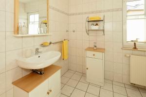 een witte badkamer met een wastafel en een spiegel bij Uns Huesung in Ahlbeck +25 foto's