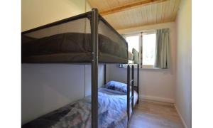 ein Schlafzimmer mit einem Etagenbett in einem Zimmer in der Unterkunft Bungalow aan de Visbeekvallei in Vlimmeren