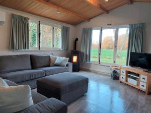 a living room with a couch and a tv at Bungalow aan de Visbeekvallei in Vlimmeren