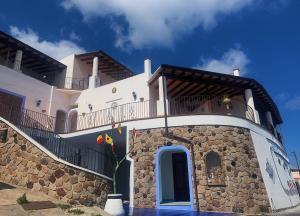 Un grand bâtiment blanc avec un balcon est disponible. dans l'établissement Stella del Mattino, à Lipari