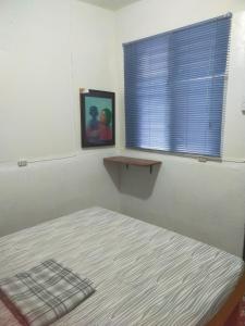 um quarto com uma cama e uma janela com uma fotografia em Nomad Homestay em Moalboal