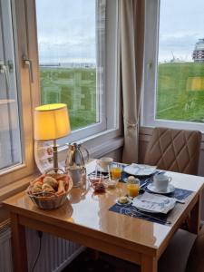 ein Tisch mit einer Schüssel Brot und einer Lampe in der Unterkunft Hotel Beckröge in Cuxhaven