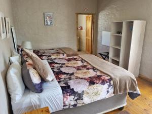 a bedroom with a large bed with a floral blanket at Baroe House in Sutherland