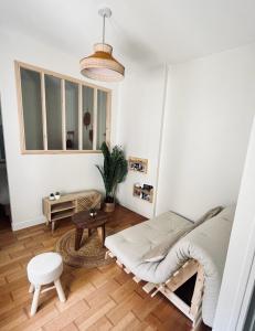 een woonkamer met een bank en een tafel bij Studio «  La Mouette Rieuse » in Le Touquet-Paris-Plage