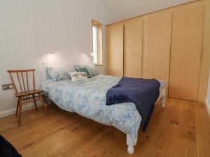 a small bedroom with a bed and a chair at The Beehive in Exeter
