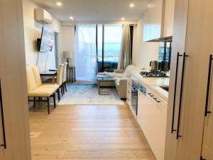 a kitchen and dining room with a view of a living room at M-city Apartment - Executive Twin King Ensuites - Fully equipped - Free Parking, fast Wifi, smart TV, Netflix, complementary drinks & amenities - M-city shopping centre Clayton 3168 in Clayton North