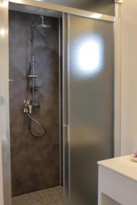 y baño con ducha y puerta de cristal. en hu Roma Camping In Town, en Roma