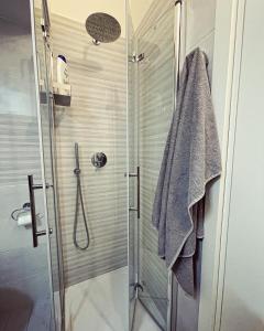 a shower with a glass door and a towel at 50 Papiniano apartment in Milan +40 photos