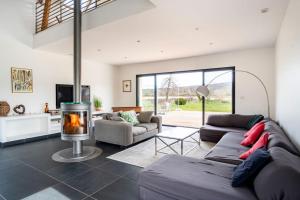 a living room with a couch and a fireplace at Villa des Vergers in Cornihout-du-Mesnil