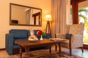 een woonkamer met een bank, een tafel en een spiegel bij White Sands Hotel in Dar es Salaam