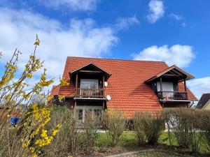 ein Haus mit rotem Dach und zwei Fenstern in der Unterkunft Ferienwohnung Hamburger Straße 7OG in Cuxhaven in Cuxhaven