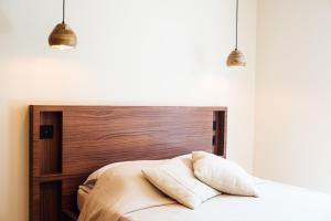 - une chambre avec une tête de lit en bois et 2 oreillers sur un lit dans l'établissement Villa Alemagou, à La Croix-Valmer