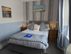 a small bedroom with a bed and two night stands at Abingdon House in Torquay