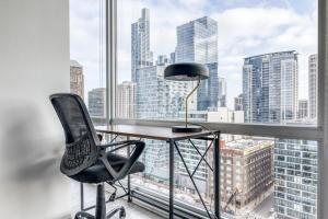 um escritório com uma secretária e uma cadeira em frente a uma janela em S Loop 1BR w Gym Lounge 1 block to L CHI-526 em Chicago