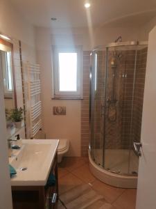 La salle de bains est pourvue d'une douche, de toilettes et d'un lavabo. dans l'établissement Apartment Helena, à Dramalj