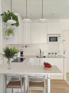 a kitchen with white cabinets and a table with a bowl of fruit at M&D Centro Málaga in Málaga