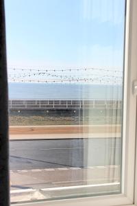 a window with a view of a road and the ocean at Sandpiper Holiday Apartments in Blackpool