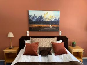 a bedroom with a bed with a painting on the wall at Honne Hotell in Biri