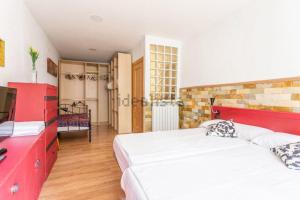 una camera con due letti e una tv di Trampantojo Apartamento en el Corazon de Pamplona a Pamplona