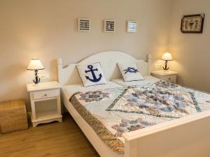een slaapkamer met een groot wit bed met blauwe kussens bij Lindenhof in Kleinwessek