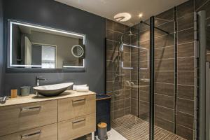łazienka z umywalką i przeszkloną kabiną prysznicową w obiekcie Kokana modern holiday home w mieście Englesqueville-la-Percée +37 zdjęć