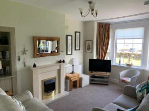 a living room with a fireplace and a television at Eilean View in Lamlash