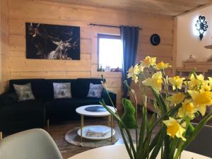 ein Wohnzimmer mit einem Sofa und einem Tisch mit Blumen in der Unterkunft Lux House Chochołów in Chochołów