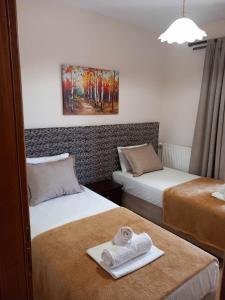 una habitación de hotel con 2 camas y una toalla en la cama en Pansion Fani, en Ouranoupoli