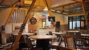 a restaurant with tables and chairs in a room at Gaia Asri Hotel in Pamanukan-hilir