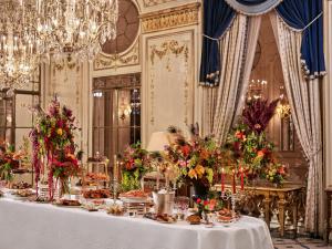 a table with food and flowers in a room at Le Meurice – Dorchester Collection in Paris