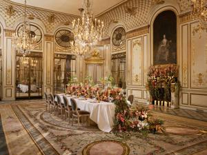 a large room with a table with flowers in it at Le Meurice – Dorchester Collection in Paris