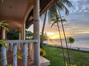 a house with a view of the ocean at sunset at Islanders Paradise Beach in Larena