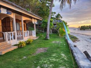 una casa sulla spiaggia con una tavola da surf di fronte di Islanders Paradise Beach a Larena